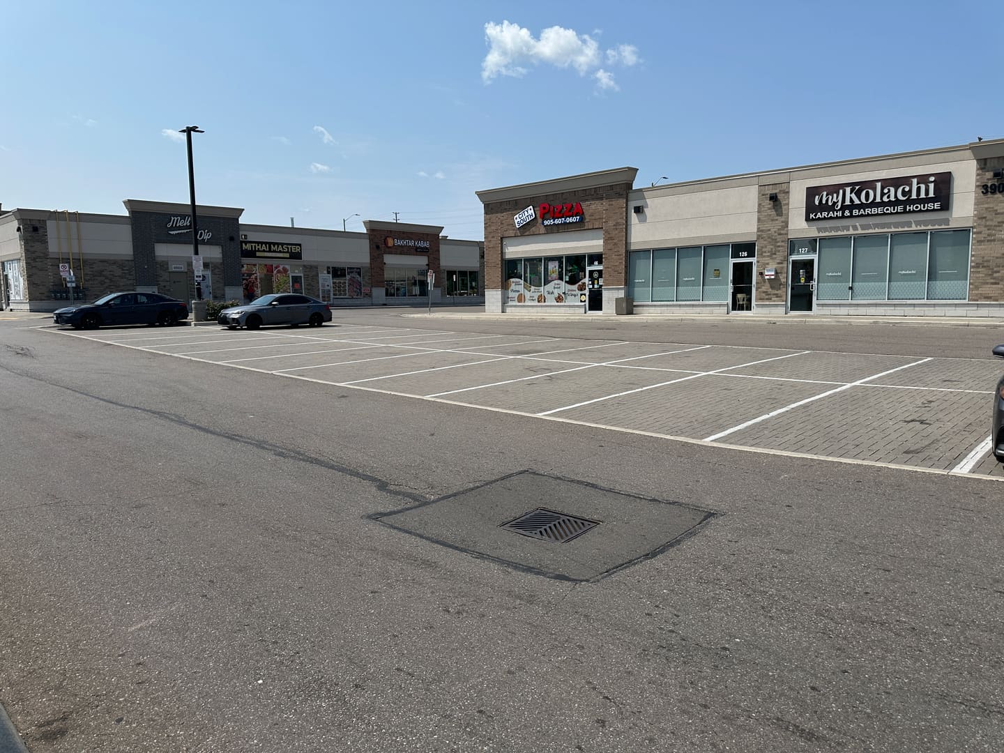 Ridgeway storefront row with Melt n Dip, Mithai Master, Bakhtar Kabab, City South Pizza and myKolachi signs