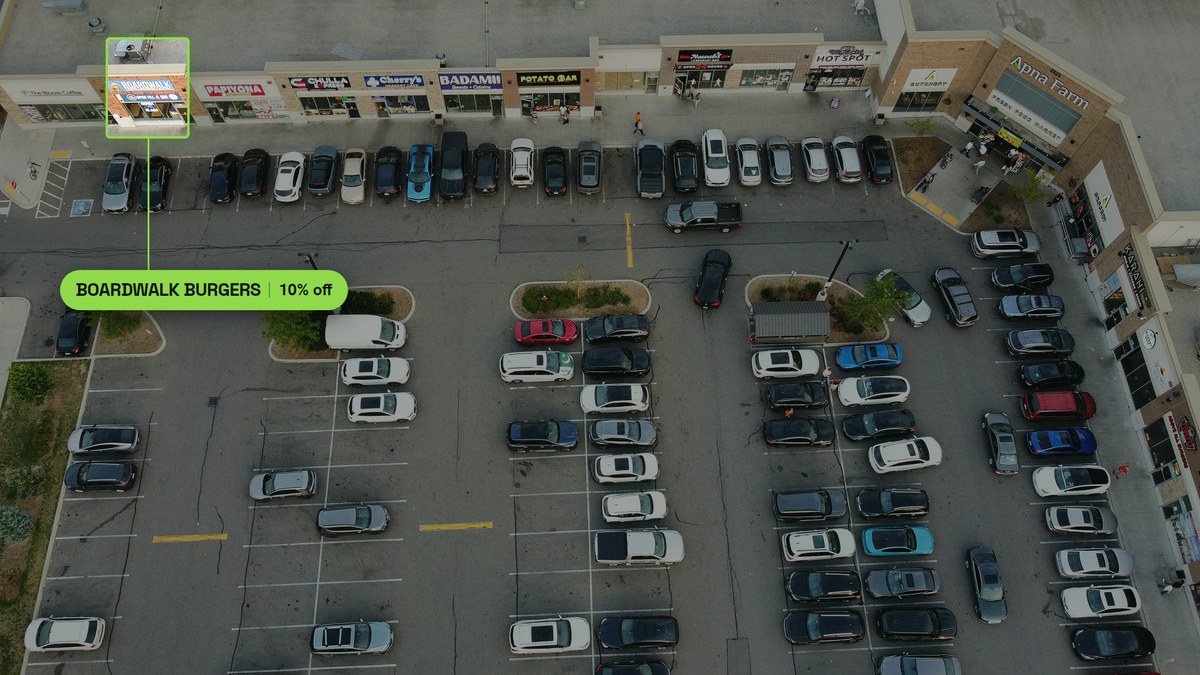 Aerial photograph of Boardwalk Burgers at Ridgeway Plaza, storefront outlined, beside The Bloom Coffee on the row anchored by Apna Farm