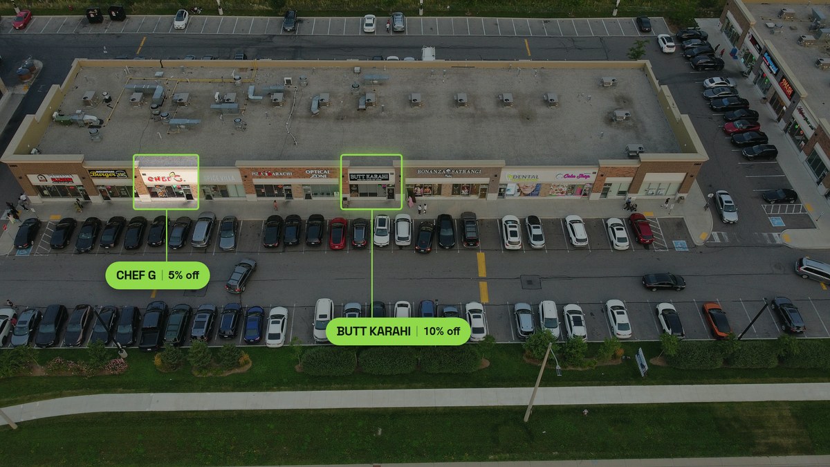 Aerial photograph of one Ridgeway Plaza strip with two storefronts outlined, Chef G and Butt Karahi, six units apart on the same row
