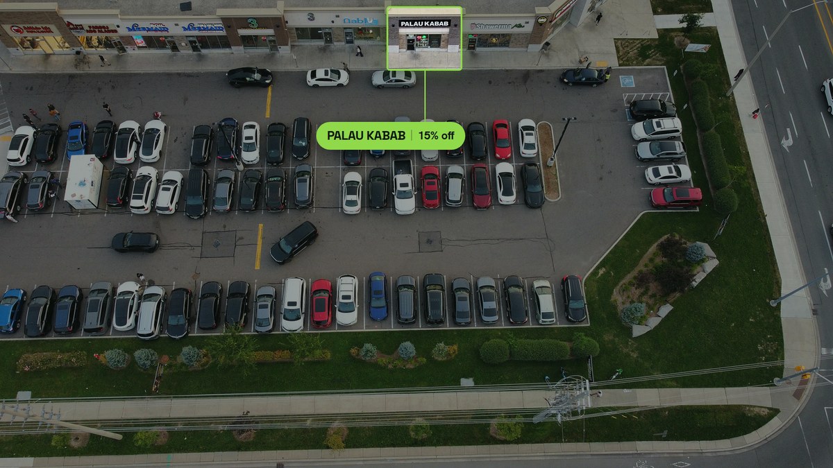 Aerial photograph of Palau Kabab at Ridgeway Plaza, its storefront outlined, sitting between Nablus Sweets and Shawarma Plus with a parking row directly in front